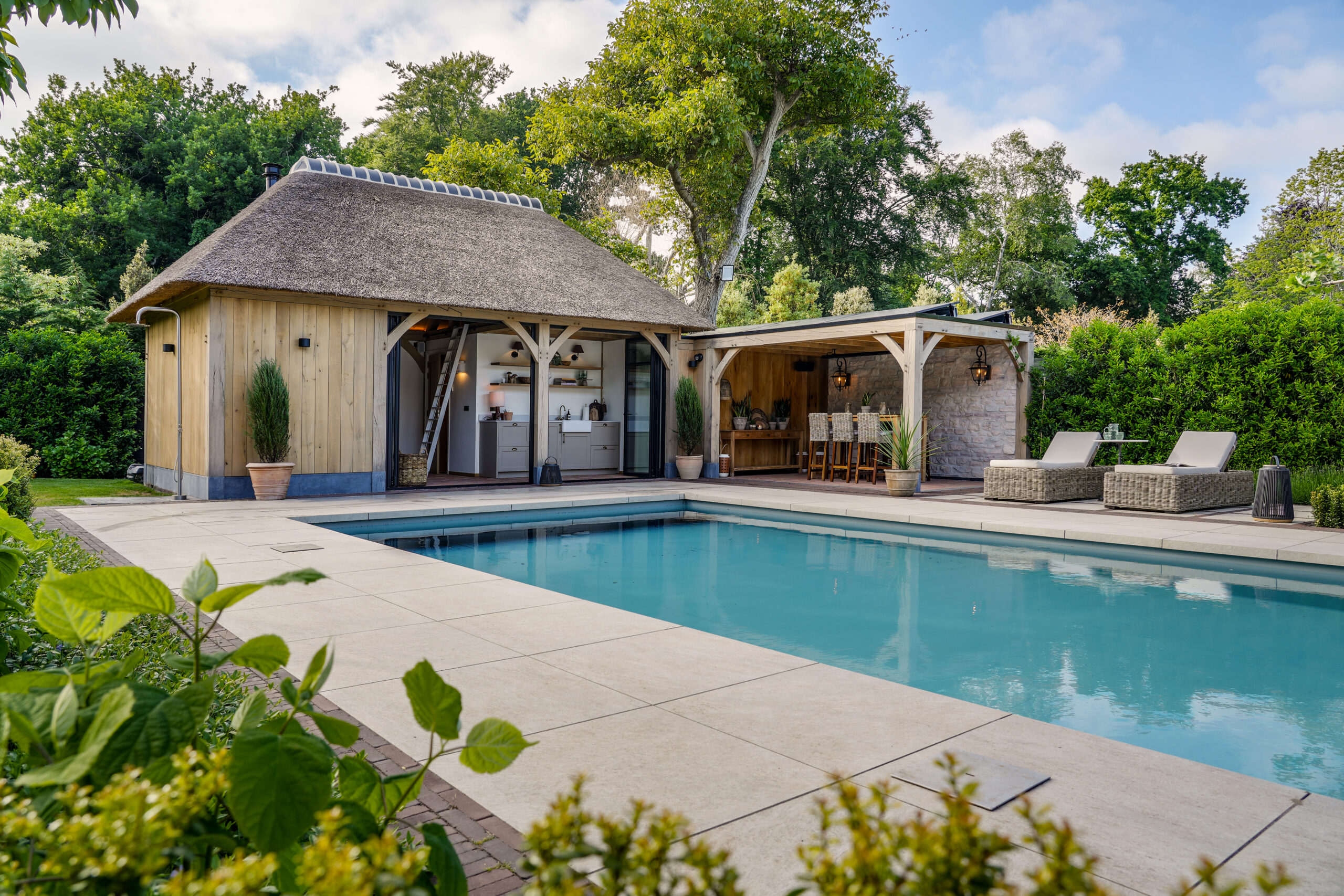 Vouwwanden voor eiken poolhouse met rieten kap