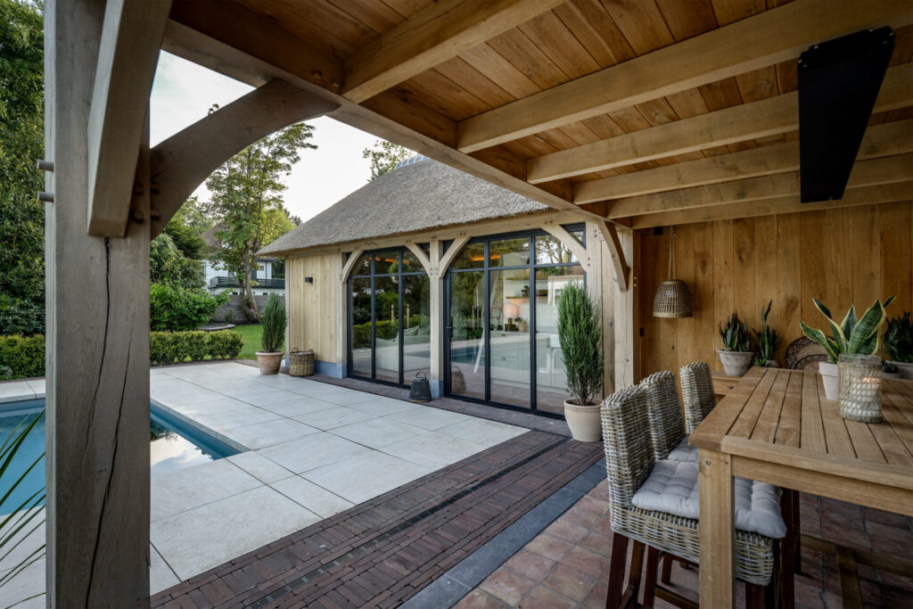 Vouwwanden voor eiken poolhouse met rieten kap